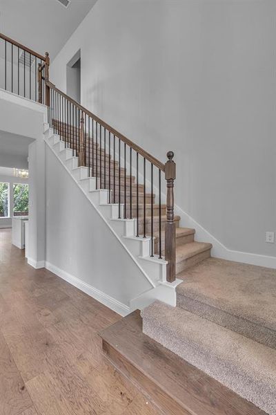 Staircase with a notable chandelier and hardwood / wood-style floors