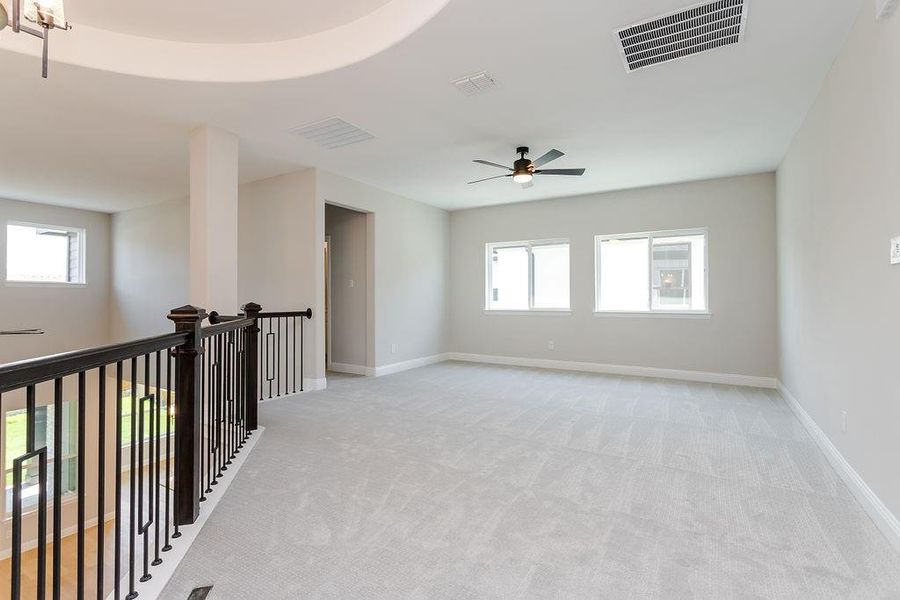 Carpeted spare room featuring ceiling fan