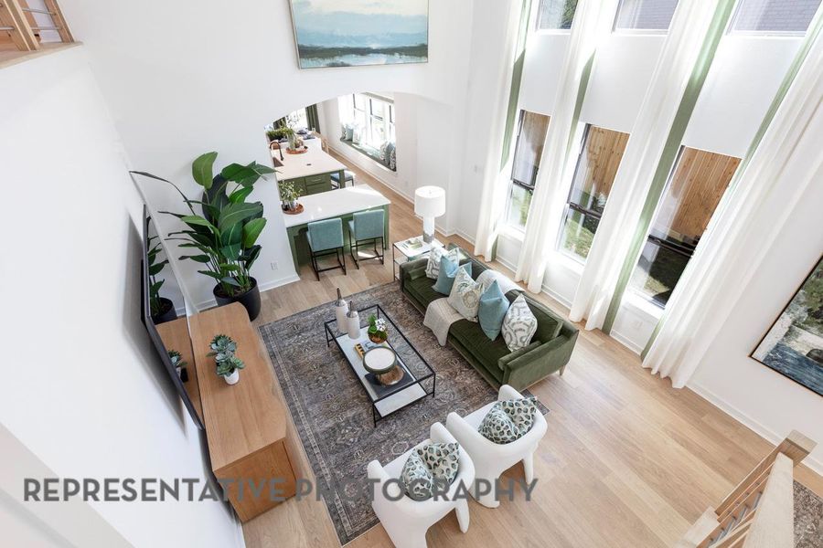 Living area with wood finished floors, arched walkways, a high ceiling, and baseboards Living area with wood finished floors, arched walkways, a high ceiling, and baseboards