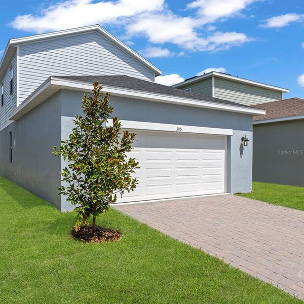 Front exterior of a new home in Spring Walk at the Junction, Debary, FL, highlighting curb appeal (Image 23).