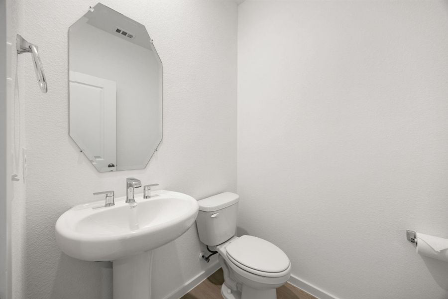 A conveniently located first-floor powder bath provides easy access for guests while keeping private living spaces separate.