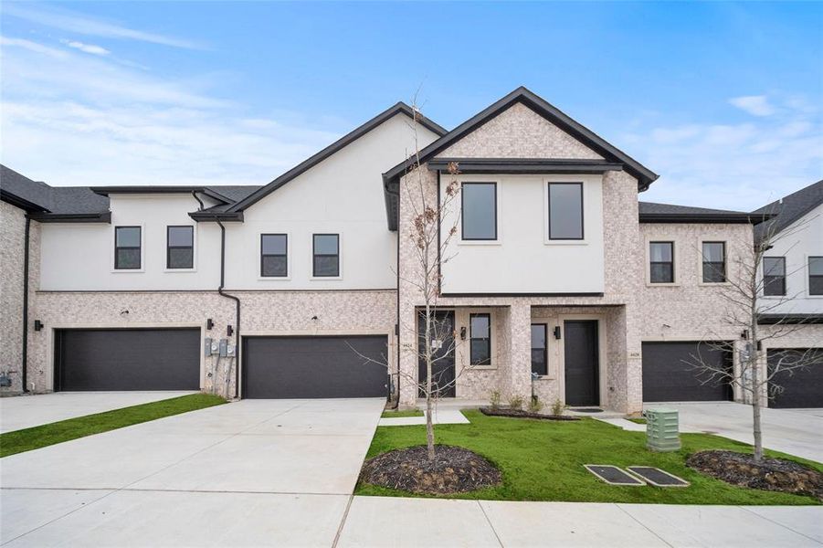 Multi unit property featuring a front yard, concrete driveway, a garage, and stucco siding