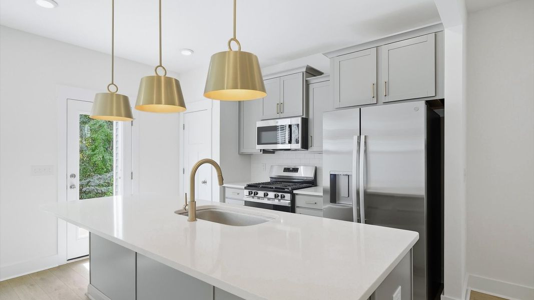Tasteful design meets functional luxury in this kitchen with a 9-foot island and modern pendant lighting at El Dorado Tasteful design meets functional luxury in this kitchen with a 9-foot island and modern pendant lighting at El Dorado