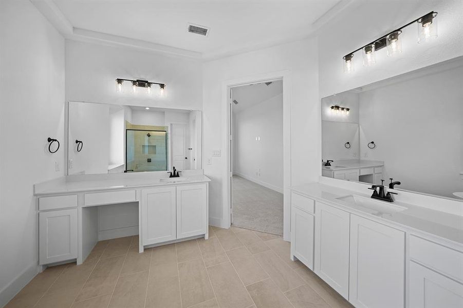 Full bathroom featuring a stall shower and two vanities