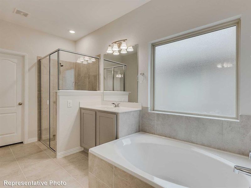 Bathroom featuring a bath, vanity, light tile patterned floors, and a shower stall