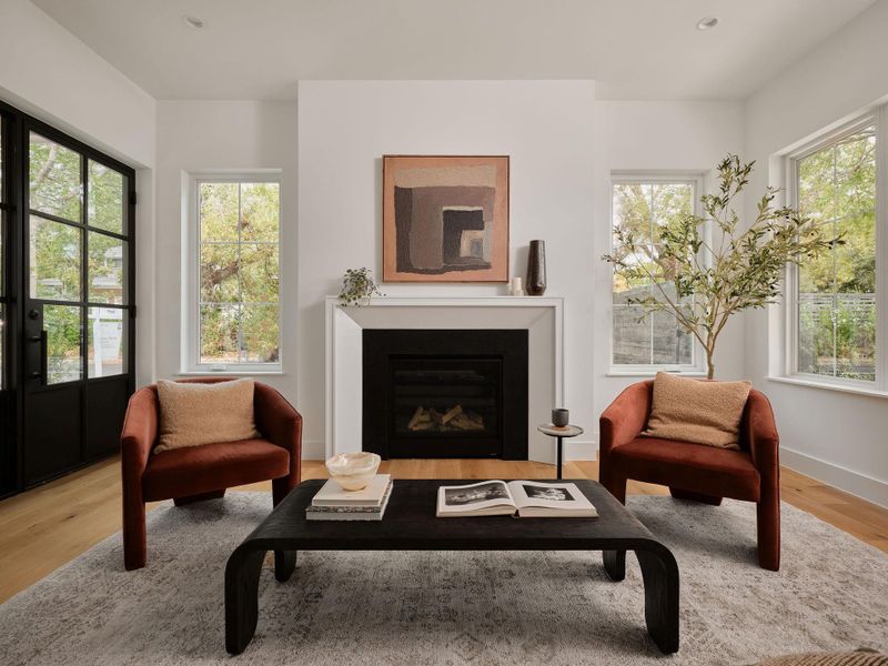Living area featuring light wood-style floors, a glass covered fireplace, and recessed lighting Living area featuring light wood-style floors, a glass covered fireplace, and recessed lighting
