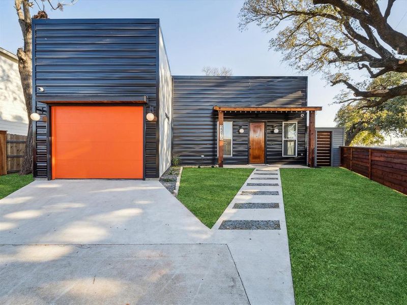 Contemporary house featuring a garage and a front lawn