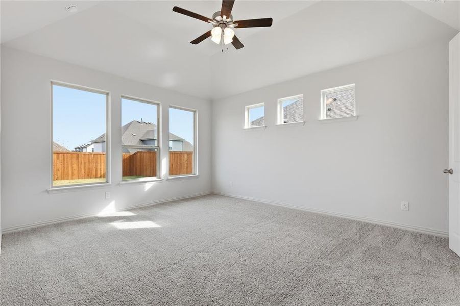 Carpeted empty room with ceiling fan and lofted ceiling Carpeted empty room with ceiling fan and lofted ceiling