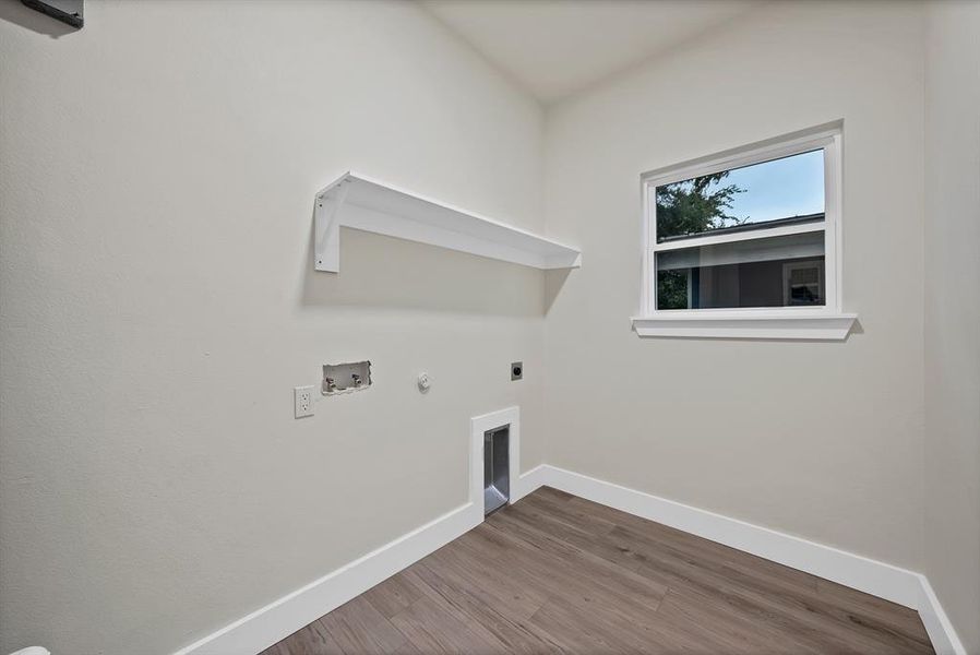 Laundry area with gas dryer hookup, hookup for an electric dryer, wood finished floors, and hookup for a washing machine