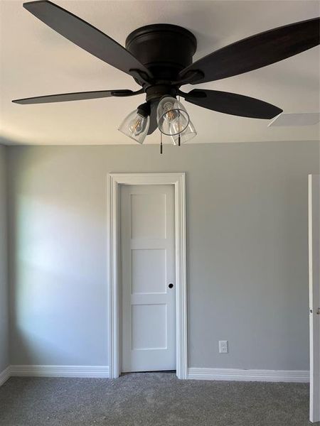 Carpeted empty room featuring ceiling fan