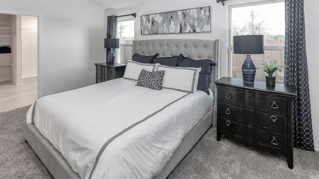 Bedroom with light carpet and vaulted ceiling