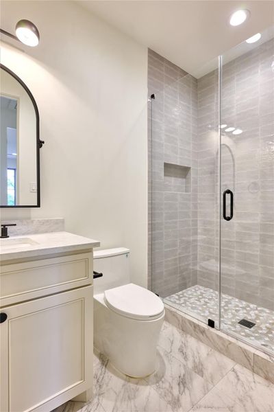 Offering a sleek walk-in shower adorned with elegant Maiolica Tender Grey wall tile and a luxurious marble mosaic floor. Offering a sleek walk-in shower adorned with elegant Maiolica Tender Grey wall tile and a luxurious marble mosaic floor.