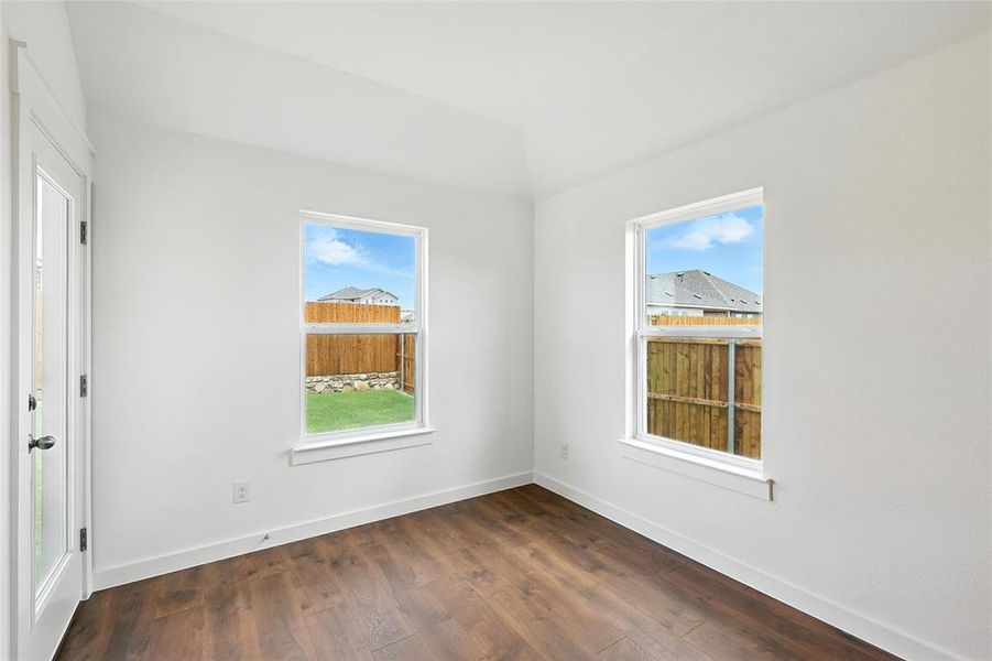 Empty room featuring dark wood finished floors and baseboards Empty room featuring dark wood finished floors and baseboards