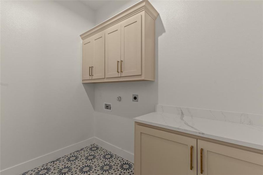Laundry room featuring cabinet space, hookup for an electric dryer, baseboards, and washer hookup Laundry room featuring cabinet space, hookup for an electric dryer, baseboards, and washer hookup