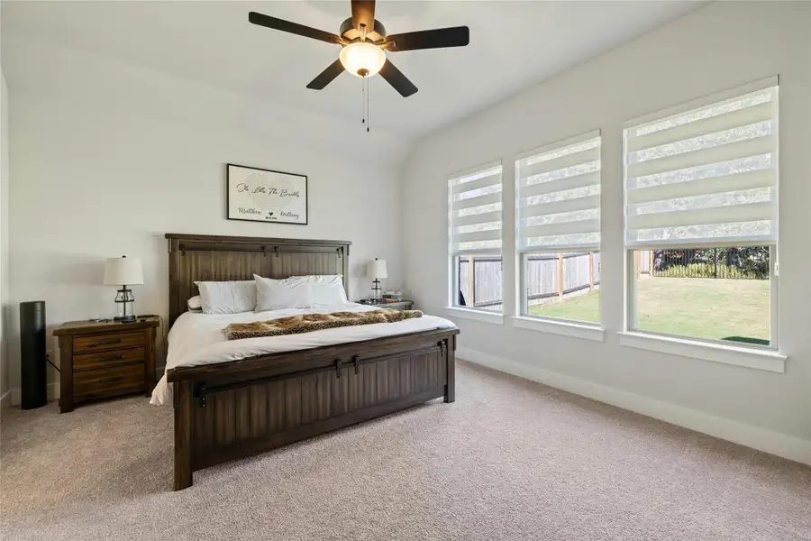 Bedroom featuring light carpet and ceiling fan Bedroom featuring light carpet and ceiling fan