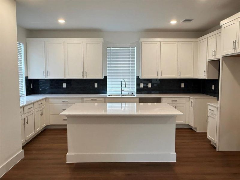 Kitchen featuring white cabinetry, a center island, dark wood-style flooring, and recessed lighting