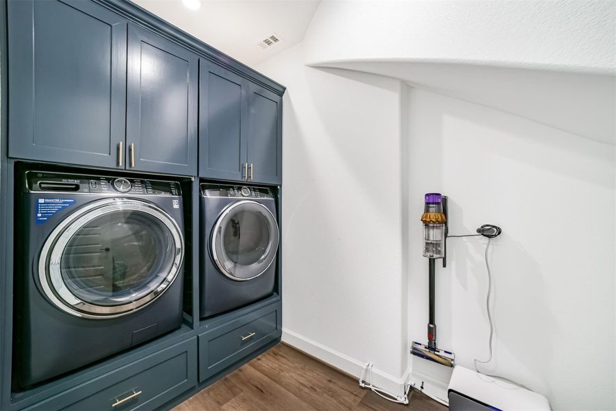 A functional utility room equipped with a washer, dryer, and ample storage cabinets. A functional utility room equipped with a washer, dryer, and ample storage cabinets.