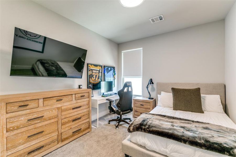 Bedroom featuring light carpet