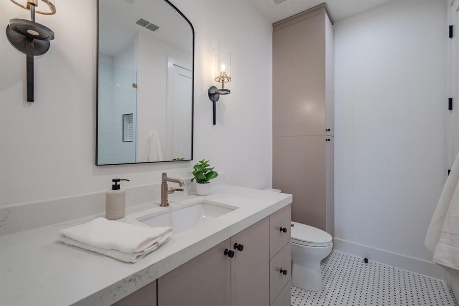 Full bath featuring vanity, a shower with door, and light tile patterned floors Full bath featuring vanity, a shower with door, and light tile patterned floors