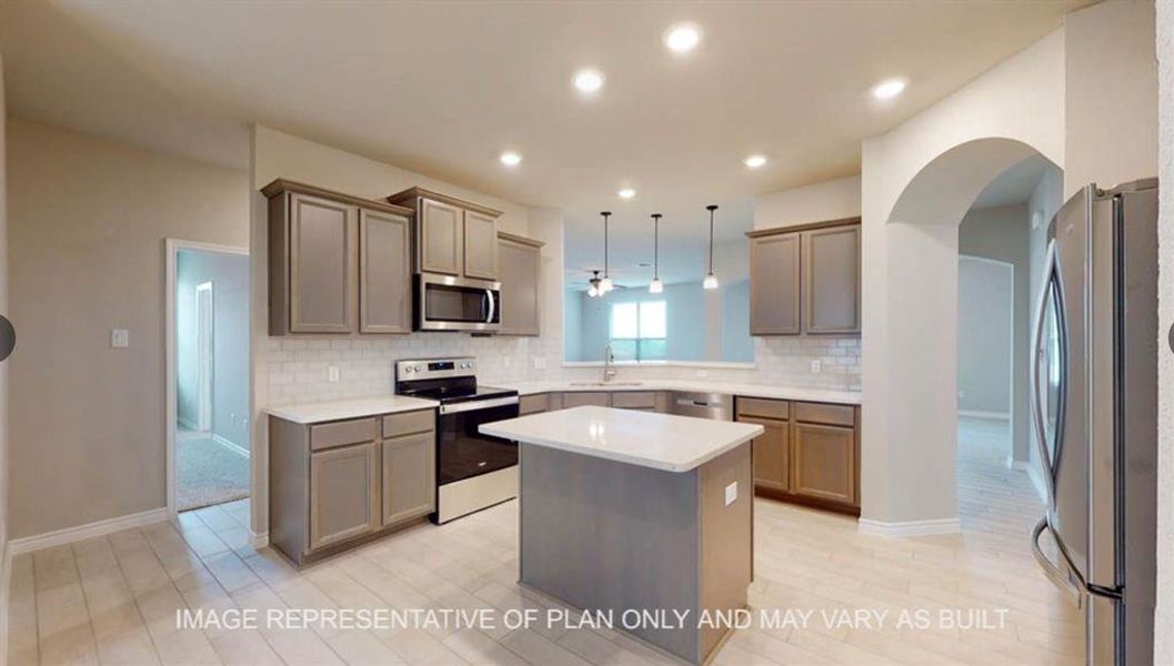 Kitchen with a kitchen island, arched walkways, appliances with stainless steel finishes, backsplash, and hanging light fixtures Kitchen with a kitchen island, arched walkways, appliances with stainless steel finishes, backsplash, and hanging light fixtures