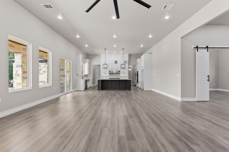 An open-concept living space integrates a spacious kitchen, featuring a central island and recessed lighting. An open-concept living space integrates a spacious kitchen, featuring a central island and recessed lighting.