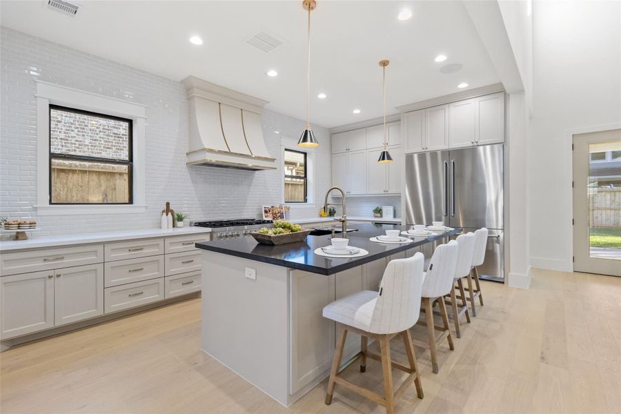 This is the kitchen you’ve been waiting for — a chef-worthy layout with a professional gas range, custom vent hood, and expansive counter space that makes cooking feel like an experience, not a chore. Your full-height cabinetry offers abundant storage while keeping the look clean and timeless, and the seamless flow from prep space to island sink makes entertaining second nature. From weeknight dinners to holiday spreads, this kitchen is built to handle it all — beautifully.