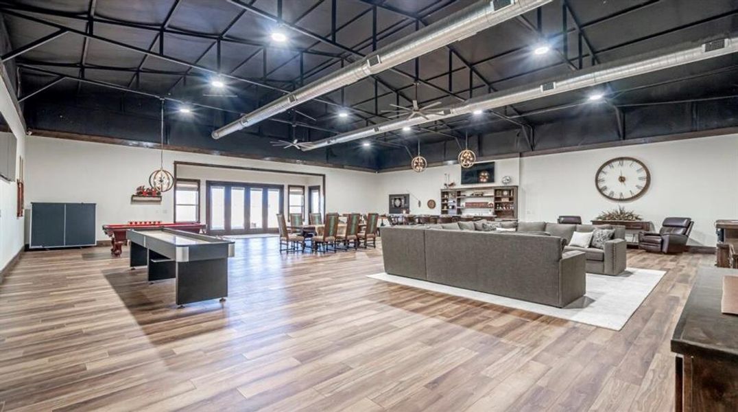 Game room featuring billiards, a high ceiling, and wood finished floors Game room featuring billiards, a high ceiling, and wood finished floors