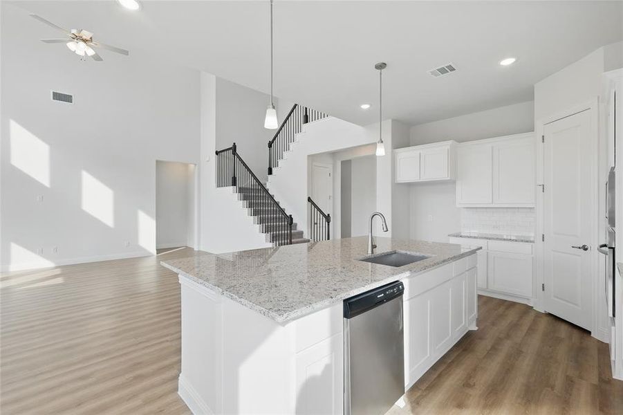 Kitchen featuring visible vents, a sink, light wood finished floors, and dishwasher Kitchen featuring visible vents, a sink, light wood finished floors, and dishwasher