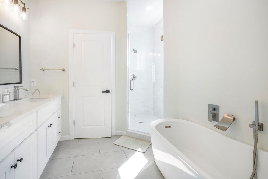Primary bathroom with a freestanding tub and separate shower.