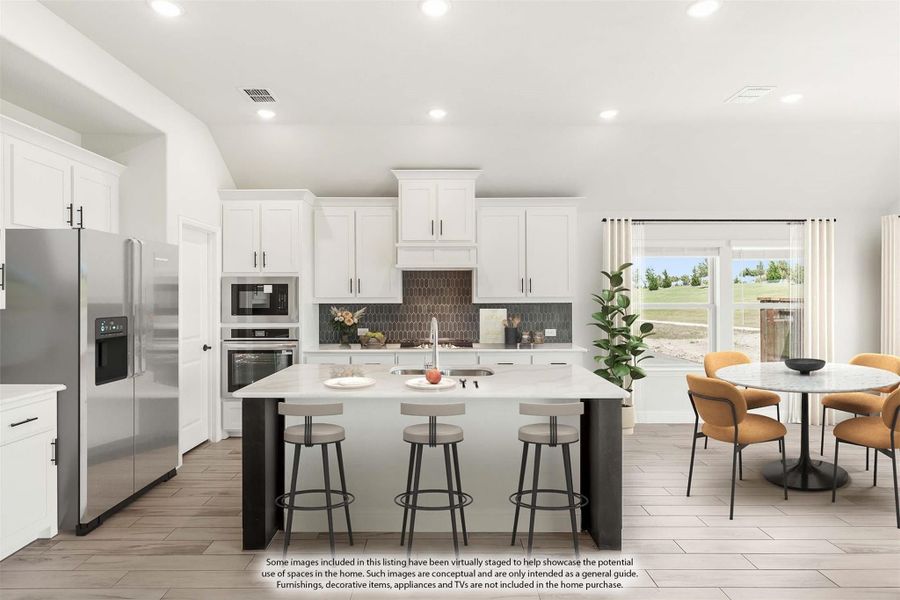 Kitchen with white cabinets, center island with bar stools, stainless steel appliances, and adjacent dining area.
