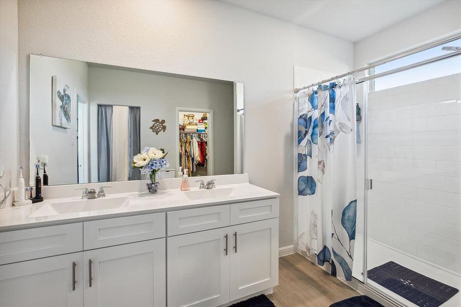 Bathroom featuring wood-type flooring and dual bowl vanity Bathroom featuring wood-type flooring and dual bowl vanity