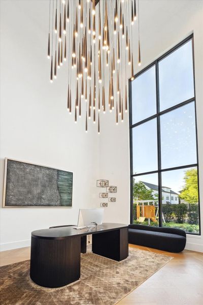 Through double doors, the foyer transitions into the private office with elegant hanging chandelier and wall of windows making a stunning first impression of elegance and sophistaced touches