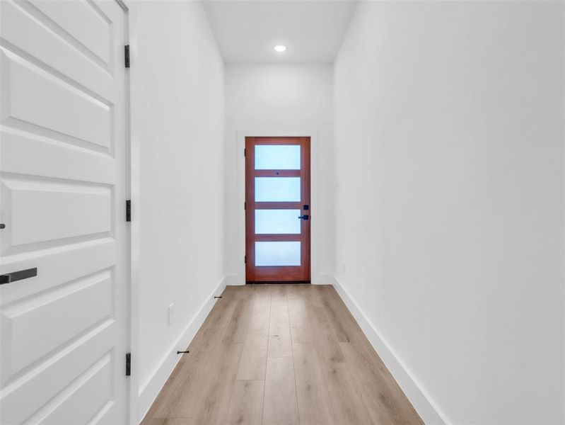 Doorway to outside featuring recessed lighting, light wood finished floors, and baseboards Doorway to outside featuring recessed lighting, light wood finished floors, and baseboards