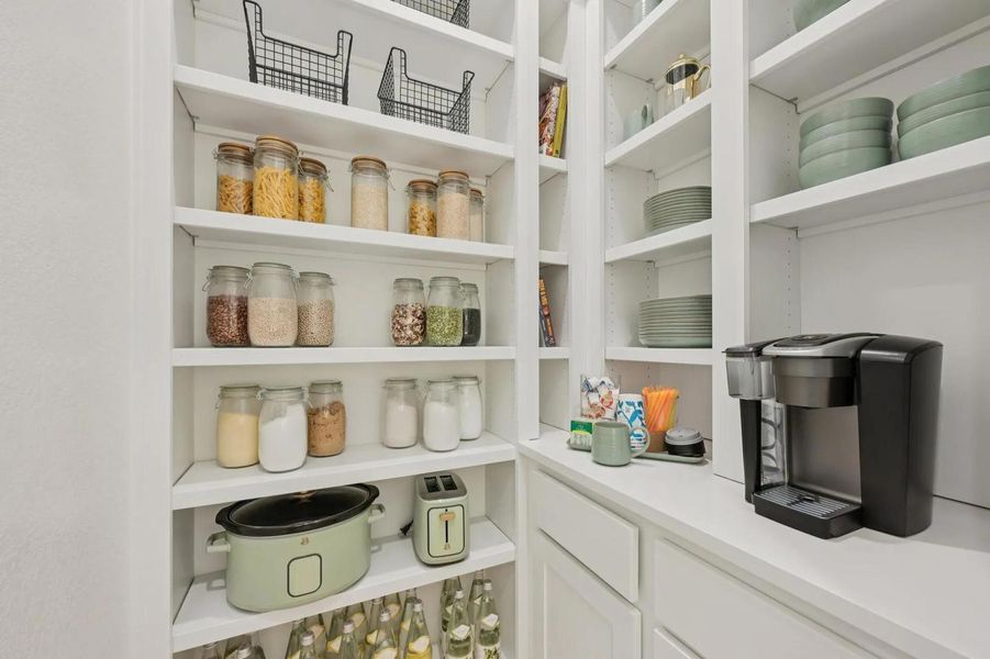 Floor-to-ceiling built-in shelving offers abundant, well-organized storage in this tidy pantry. Floor-to-ceiling built-in shelving offers abundant, well-organized storage in this tidy pantry.