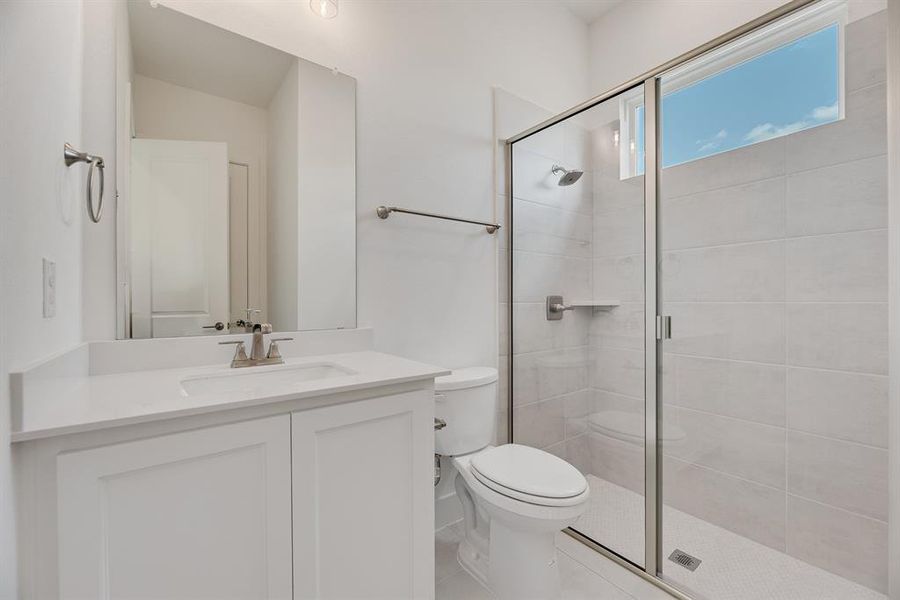 Bathroom featuring a stall shower and vanity