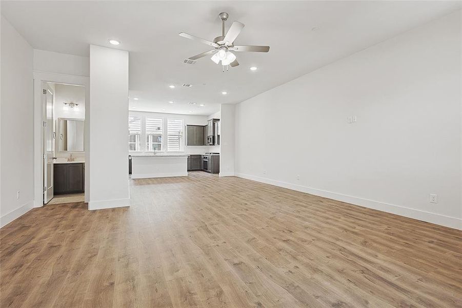 Unfurnished living room featuring light hardwood / wood-style floors and ceiling fan