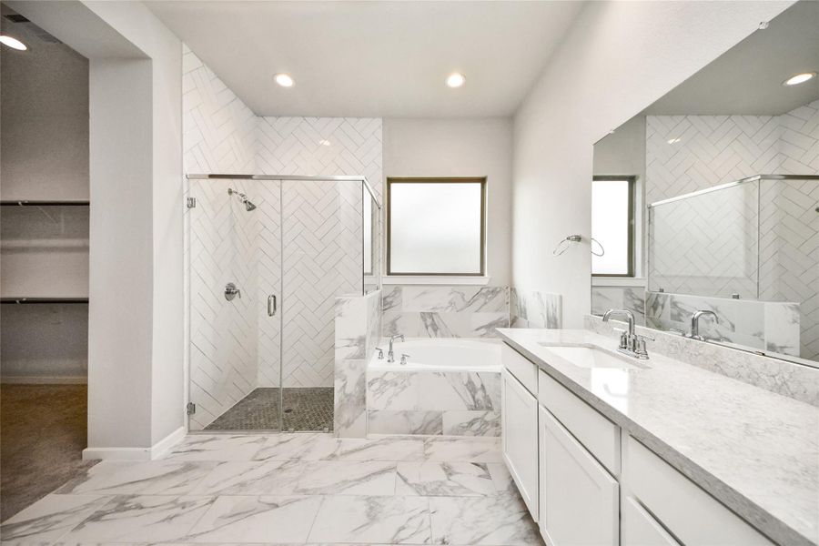 Spa-like primary bathroom with expansive vanity and walk-in shower