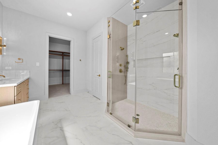 Spa-inspired primary shower featuring multiple fixtures, glass enclosure, and beautiful tilework.