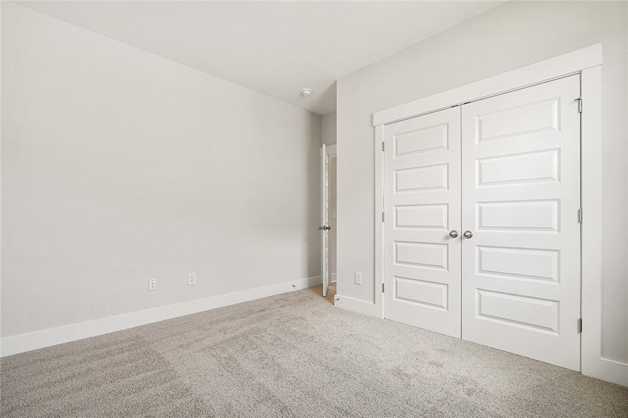 A well-lit bedroom features plush carpeting and cl A well-lit bedroom features plush carpeting and cl