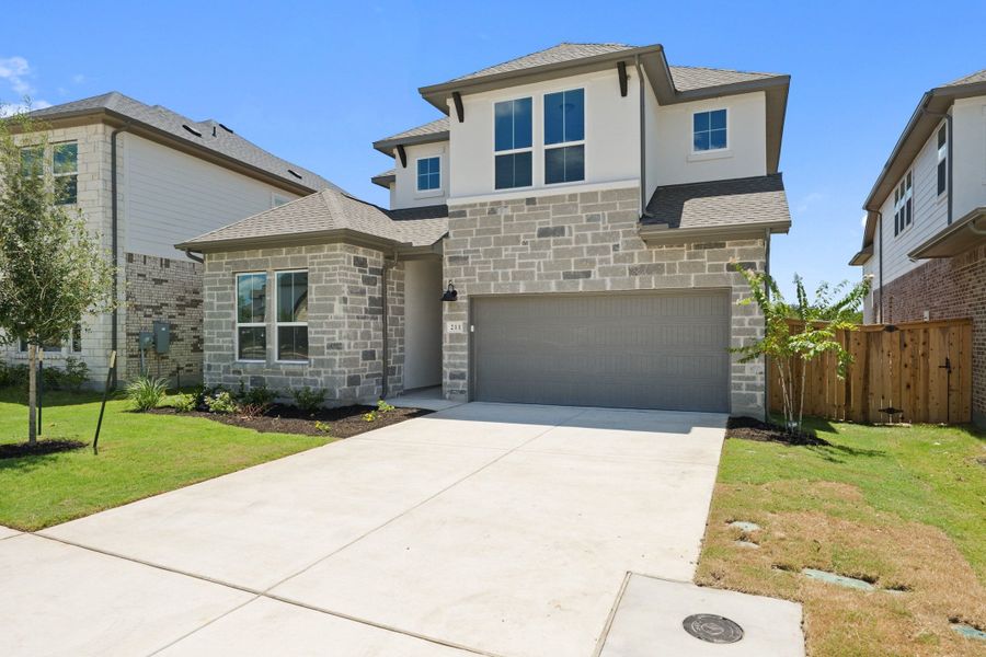 Front exterior of a new home in Heritage, Dripping Springs, TX, highlighting curb appeal (Image 1). Front exterior of a new home in Heritage, Dripping Springs, TX, highlighting curb appeal (Image 1).
