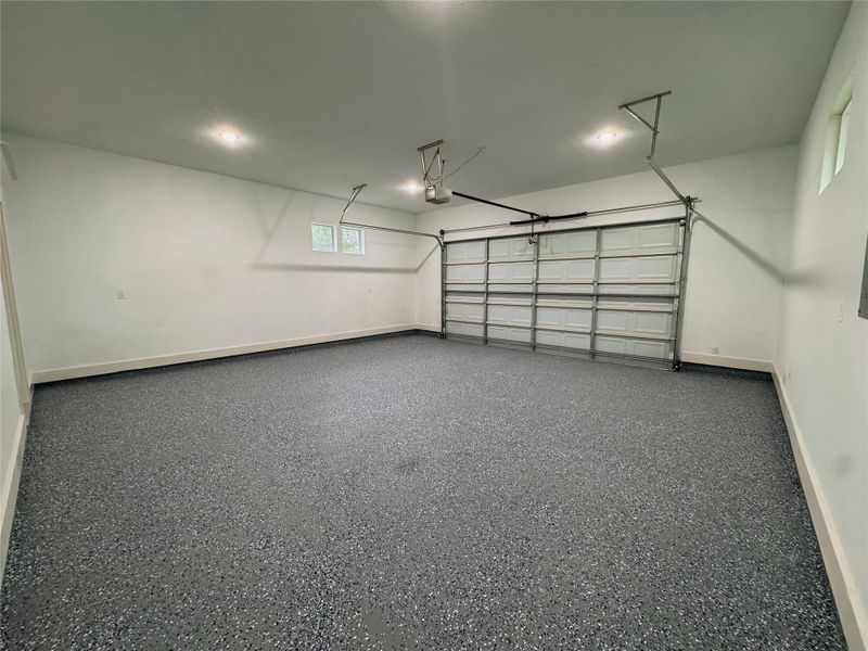 Oversized garage boasts painted flooring and automatic garage door.