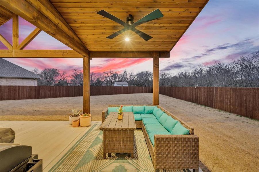 Fenced backyard with a ceiling fan, outdoor furniture, a patio area, and a grill