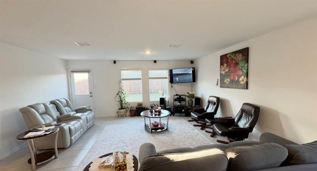 Living room featuring tile patterned floors and baseboards