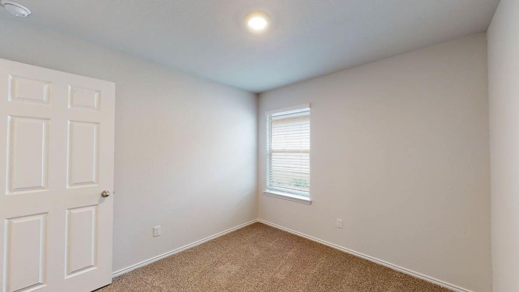 Bedroom with neutral carpeting and light-colored walls