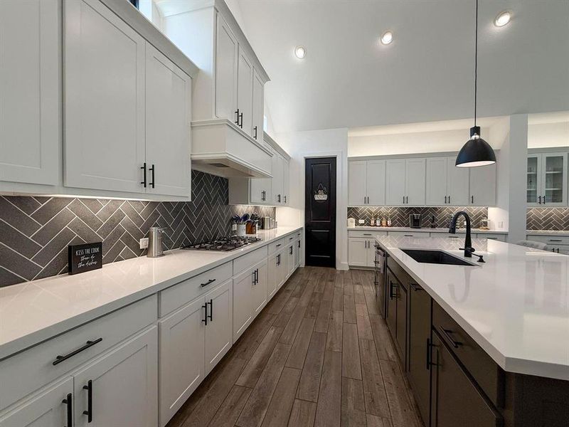 Kitchen featuring pendant lighting, backsplash, recessed lighting, white cabinets, and dark wood-style flooring Kitchen featuring pendant lighting, backsplash, recessed lighting, white cabinets, and dark wood-style flooring