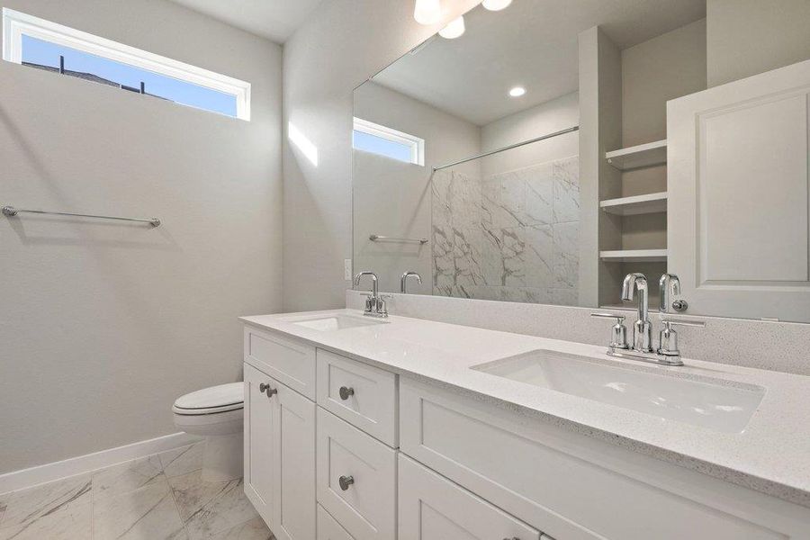 Full bathroom with double vanity, a marble finish shower, and light marble finish floors