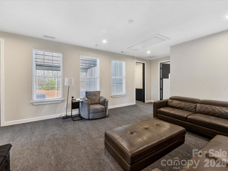 Spacious bonus room with ample natural light, flexible seating, and plenty of space for a media or recreation area.