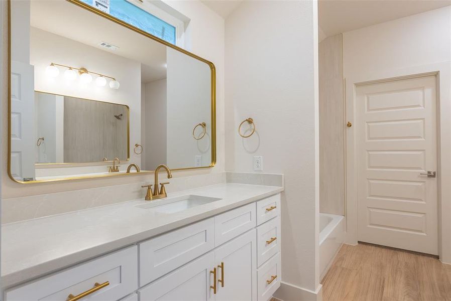 Bathroom featuring vanity, light wood finished floors, and shower / bathtub combination