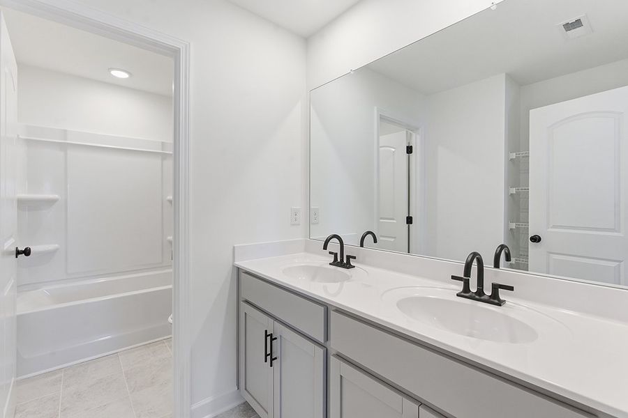 A bathroom with a sink and a mirror.