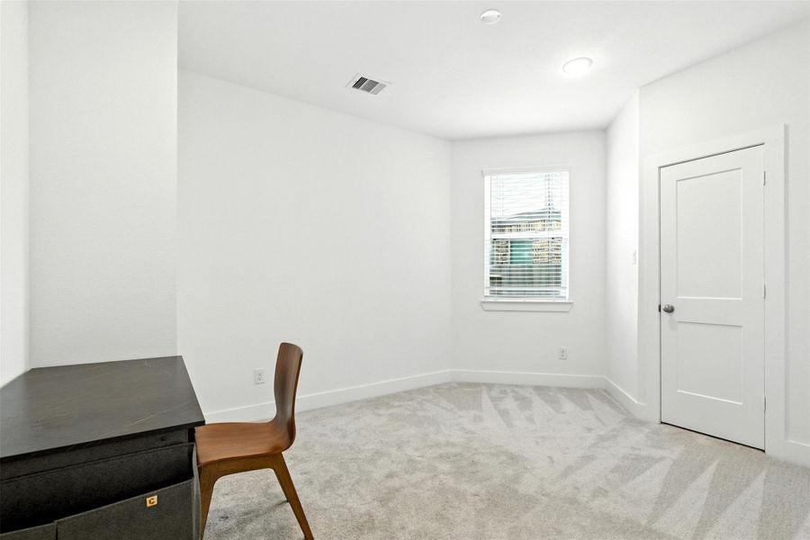 The secondary first floor bedroom features a largewindow and plush carpet. The secondary first floor bedroom features a largewindow and plush carpet.